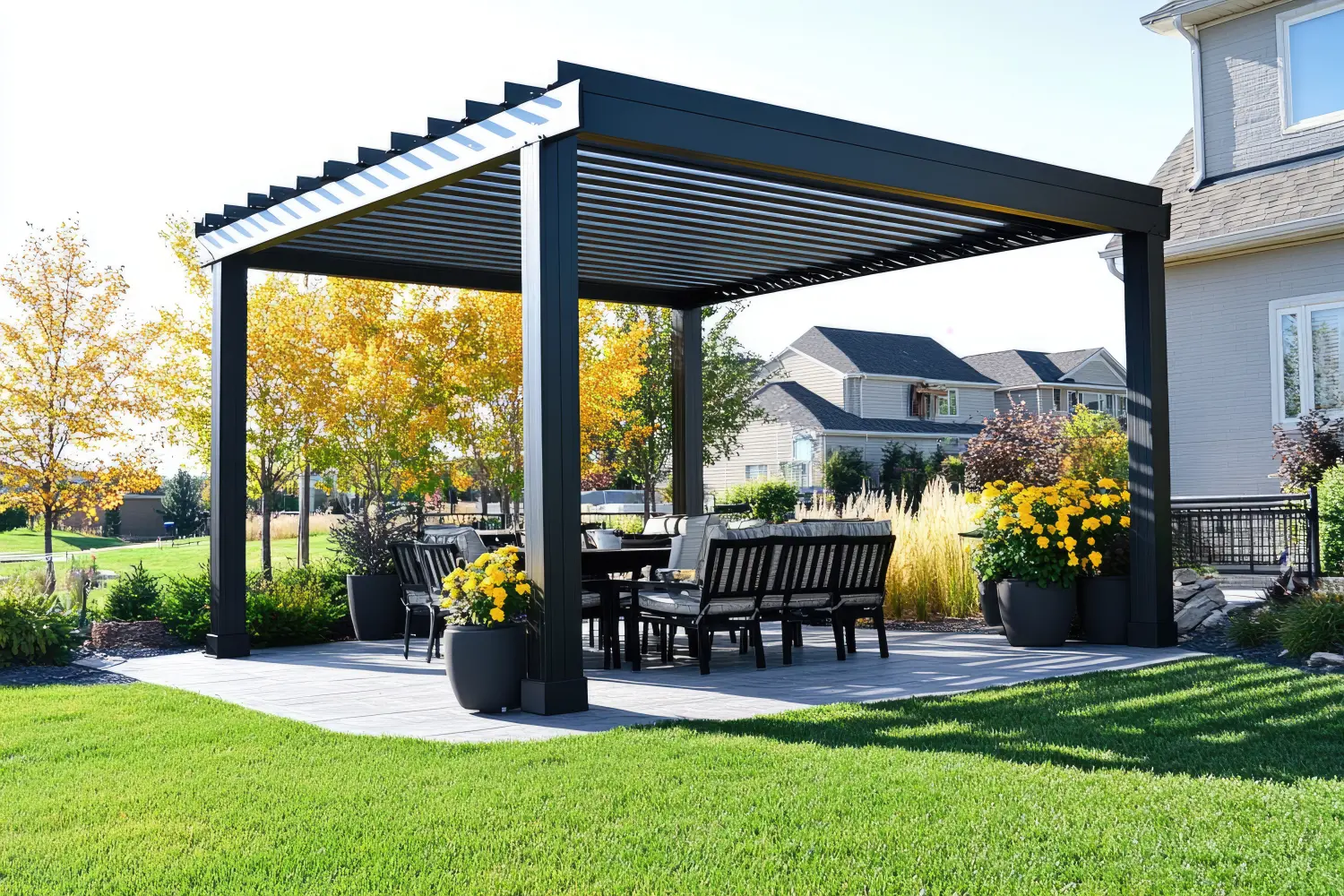 Ein moderner schwarz-weißer Metallpavillon mit horizontalen Lamellen auf dem Dach, der in einem Außenwohnbereich eines Hauses steht.